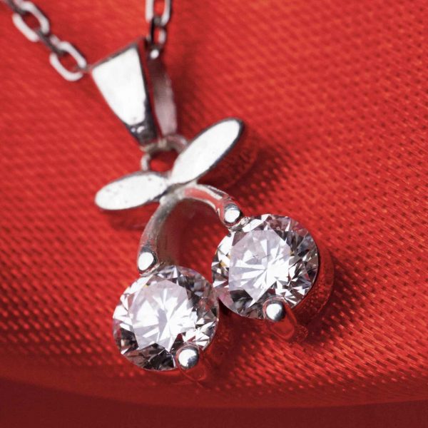 Macro close-up of cherry diamond necklace pendant with two brilliant 0.5ct round diamonds in 925 sterling silver.